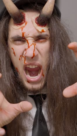 man in demon costume with special effects makeup and aggressive expressions