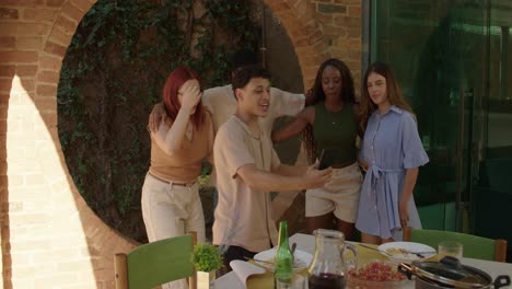 diverse group of friends taking selfies and socializing at an outdoor gathering