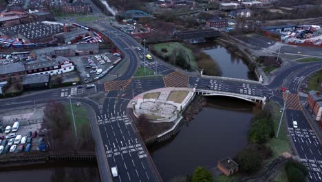 aerial early morning city street traffic commuting intersection lanes crossing curved river rising birdseye