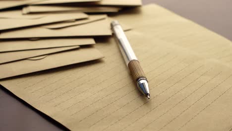 brown envelopes and paper with a pen