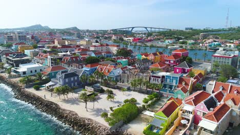 vibrant red yellow blue building facades of punda willemstad curacao along clear caribbean coastal waters