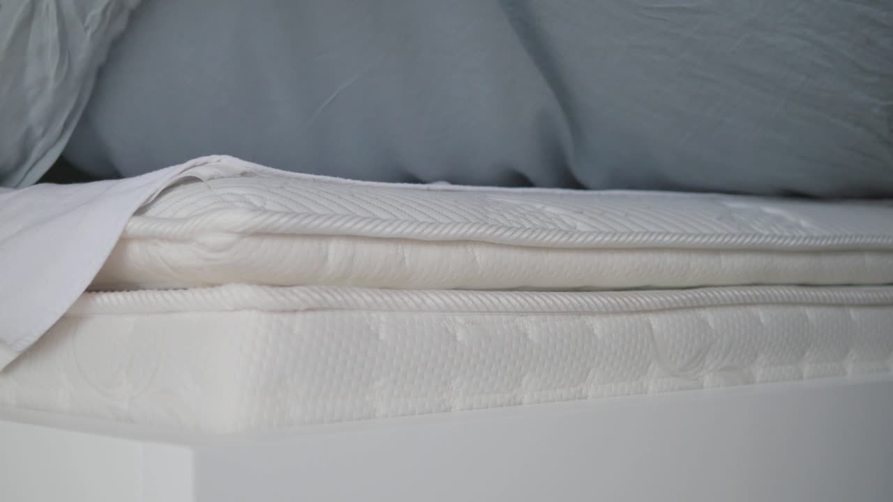 Close-up of a bed and mattress with sheets and bedding