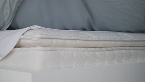 close-up of a bed and mattress with sheets and bedding
