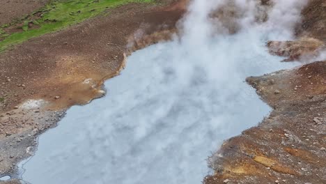 Vista-Aérea-De-La-órbita-De-Un-Dron-Desde-Una-Altitud-Media-Del-Lago-De-Vapor-De-Engjahver-En-La-Península-De-Reykjanes-En-Islandia