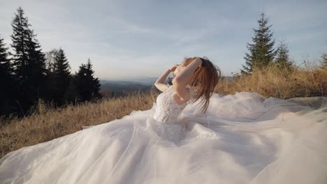 novia en vestido de novia posando en un campo de montaña al atardecer