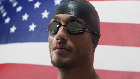 young biracial athlete swimmer in swim gear poses confidently