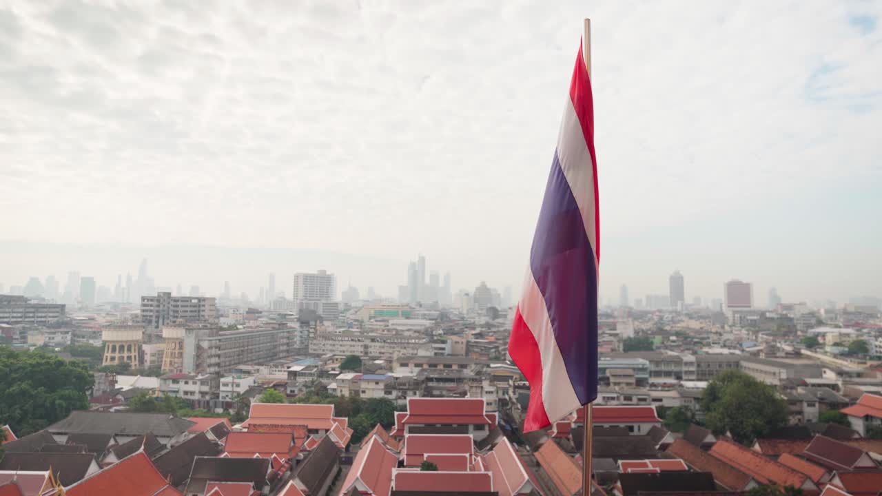 Bandiera di stato thailandese 4K che sventola al vento sulla cima del Monte d'Oro Wat Saket con Bangkok sullo sfondo.