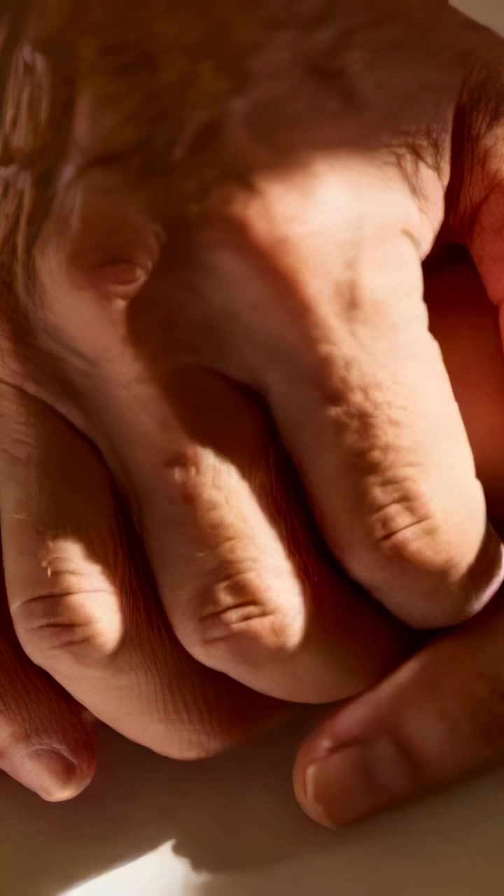 Vertical video: Adjusting senior hands pressing grip and turning on table, with warm light shifting