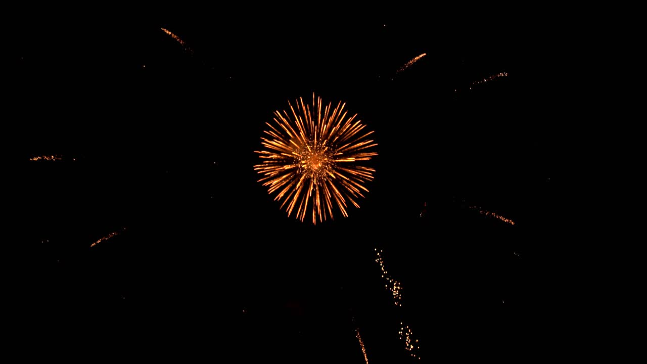 Sparkles and shimmering light of fireworks exploding in the dark black night sky