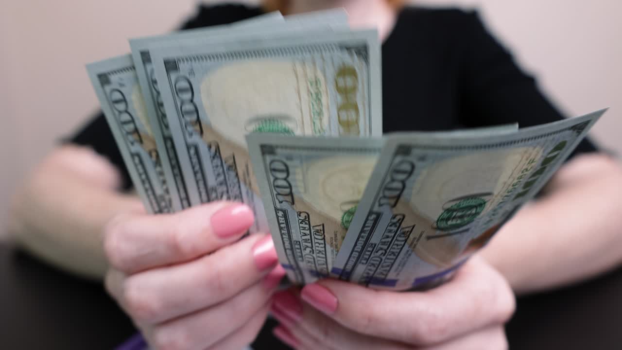 dólares en las manos de una mujer, la chica cuenta billetes, dinero de papel. presupuesto familiar, pago de facturas