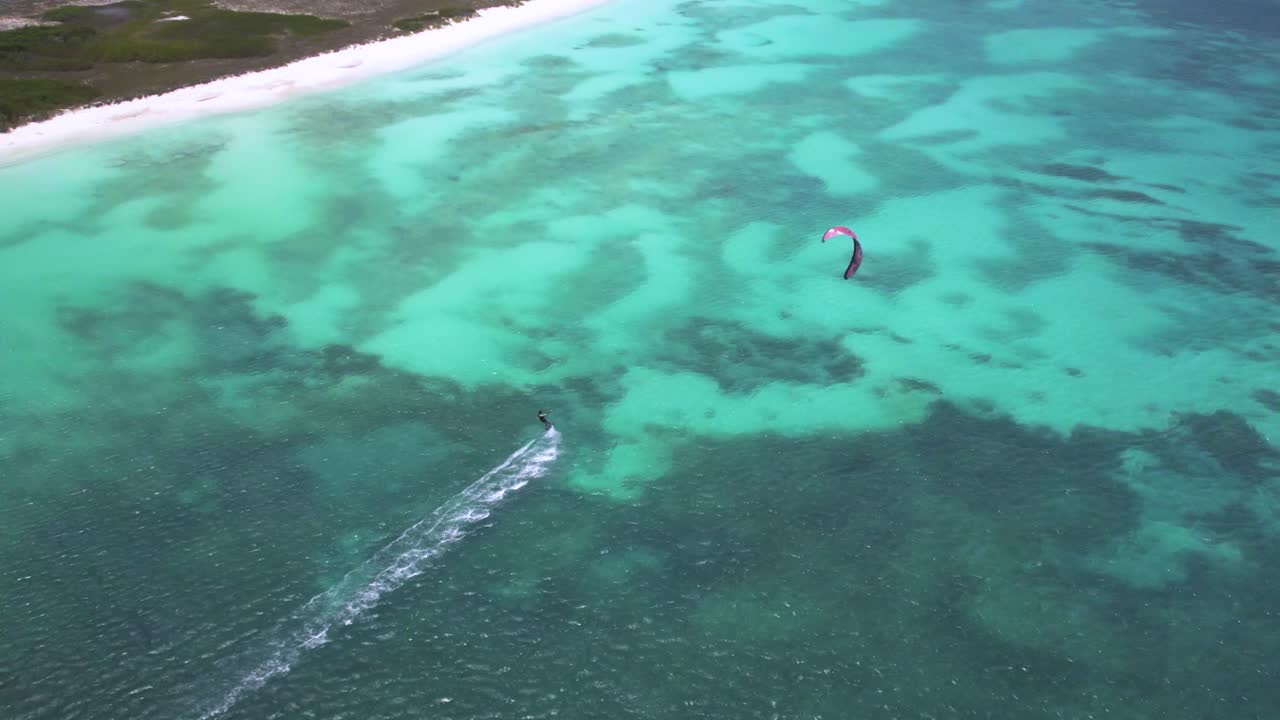 카이트보더들은 베네수엘라의 로스 로케스 (los rocas) 의 크래스키 해변 근처의 색 물 위를 날아다닙니다.