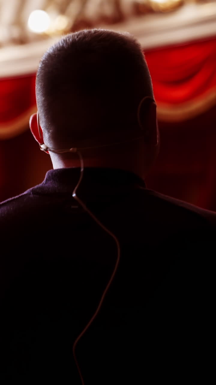 Man entertainer, presenter or actor on stage. Active gestures of clapping to the auditorium. View of a male public speaker speaking at the microphone. Vertical video