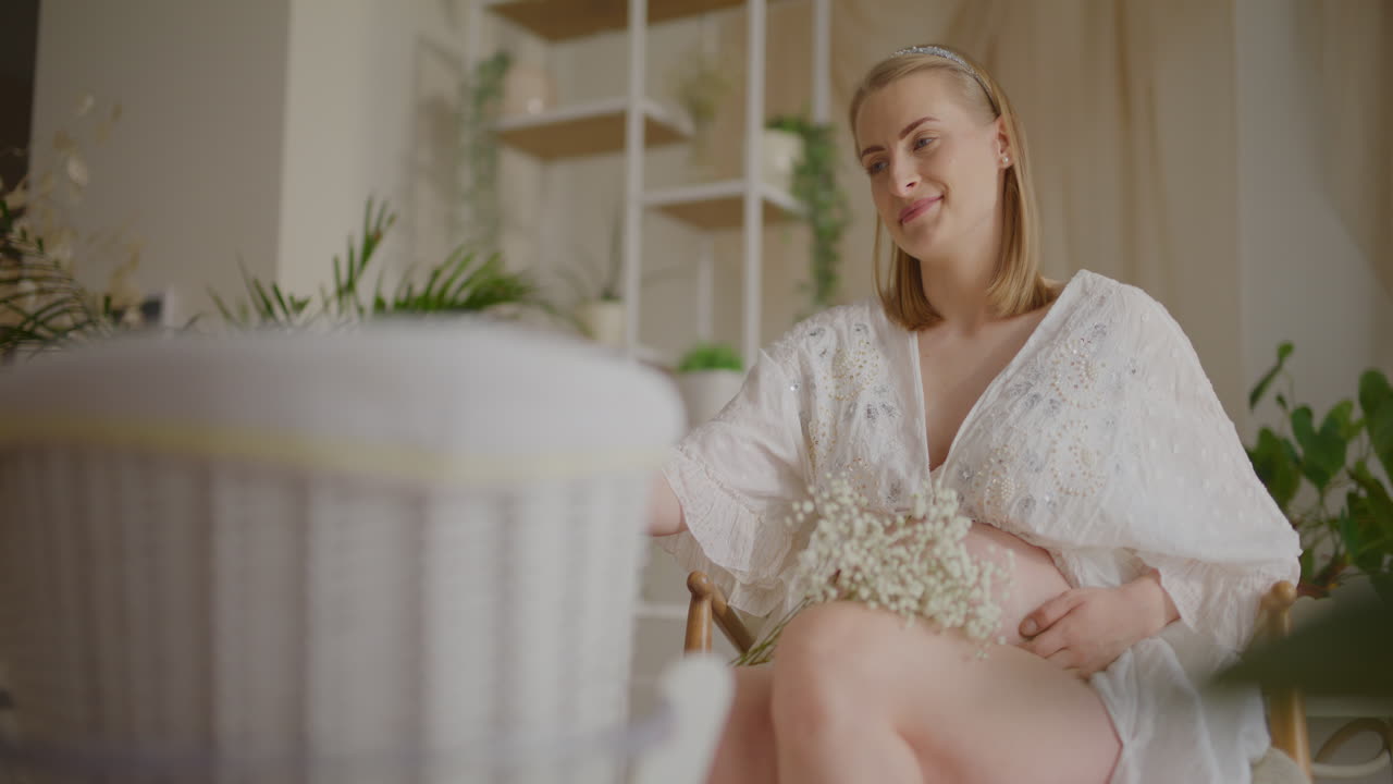 Pregnant Woman Rocking Baby in Cradle