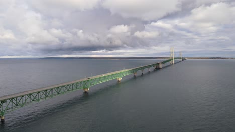 Toma-Aérea-Del-Puente-Mackinac-En-Michigan,-Ee.uu.,-Día-Nublado-Mientras-El-Tráfico-Pasa-Sobre-El-Lago