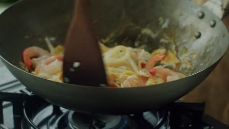 woman stirring ingredients in frying pan