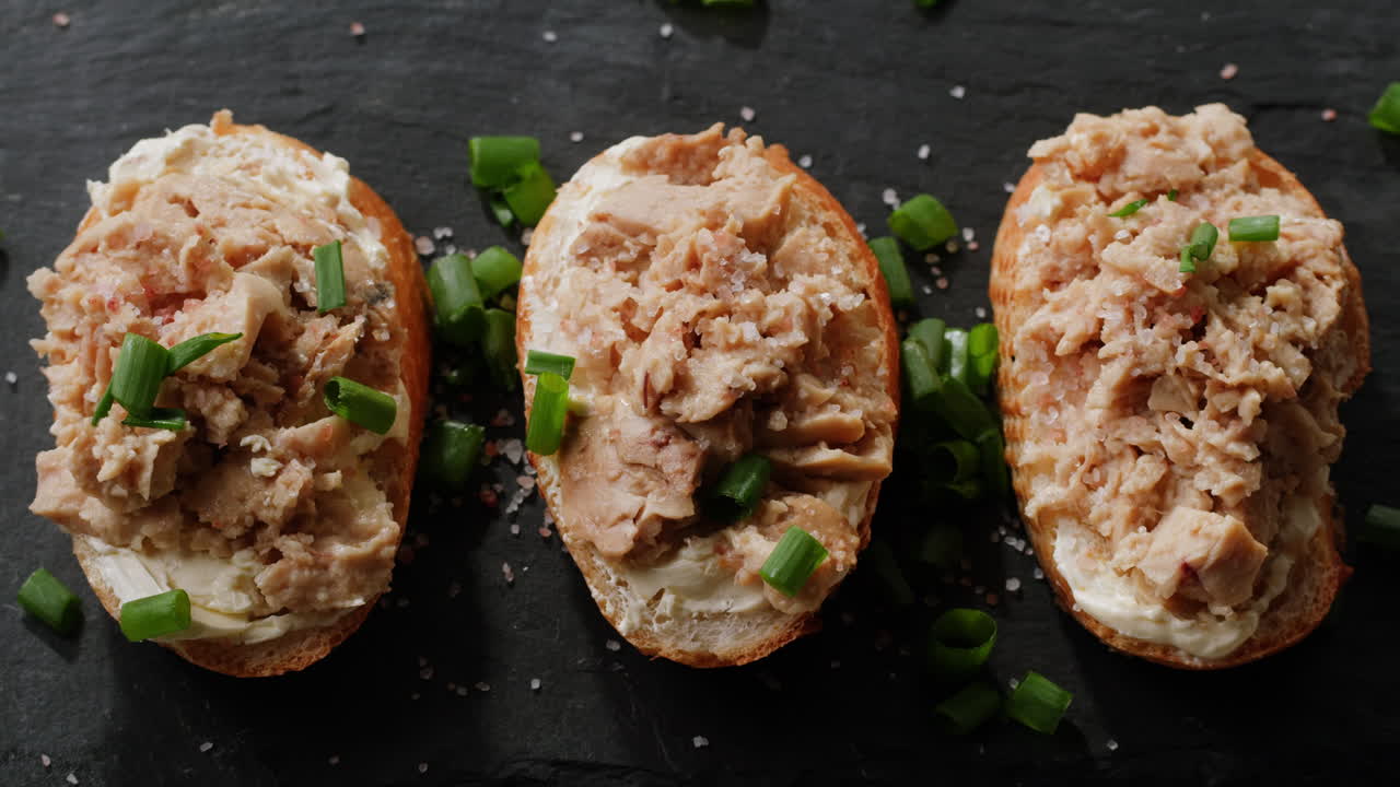 Smoked cod liver in oil in open tin can with fresh greens on wooden table. Seafoods delicacy. High quality 4k footage