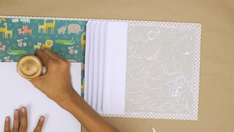 Using-adequate-glue-to-attach-decorative-elements-to-a-baby-scrapbook