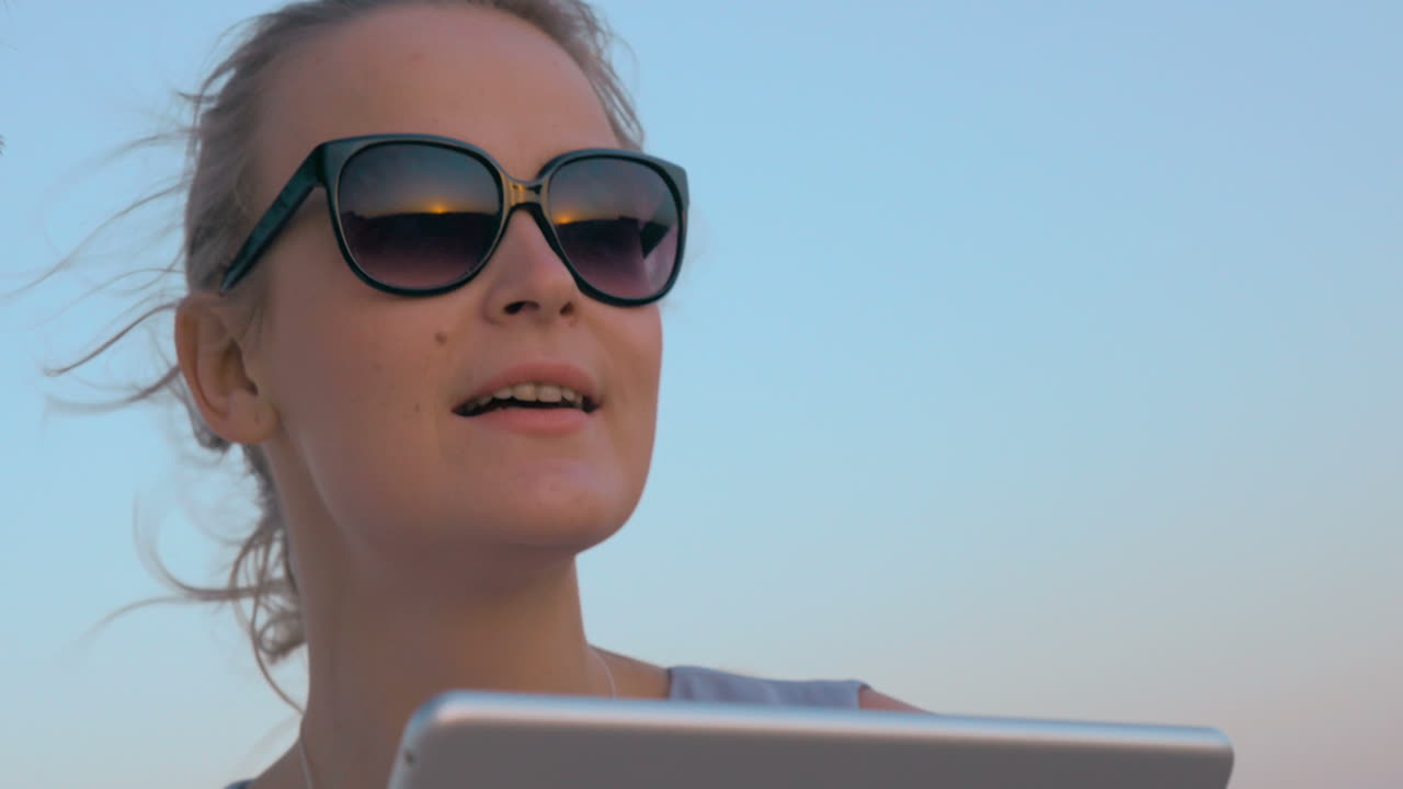 젊은이들이 해가 지는 것을 보고 패드를 사용합니다.