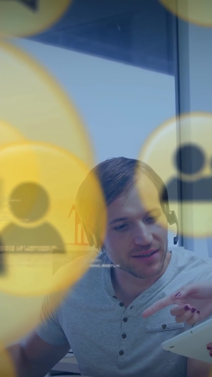 Video verticale: Uomo con cuffie che studia un tablet mentre indica, icone gialle che guidano il business.