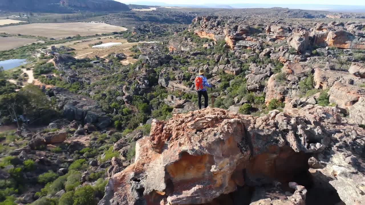 escalador masculino de pie sobre una montaña rocosa 4k