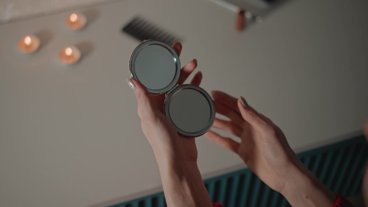 Overhead interior sequence showing hands lifting and rotating round metal-framed sunglasses toward ceiling for inspection or adjustment, then reaching across neutral tabletop to place or adjust