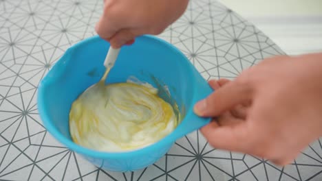 hombre mezclando los ingredientes para el relleno de pasteles en un tazón azul