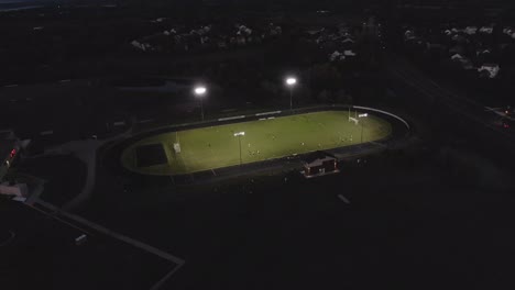 Luftaufnahmen-Eines-Fußballstadions-Mit-Eingeschalteten-Lichtern,-4K-Drohne