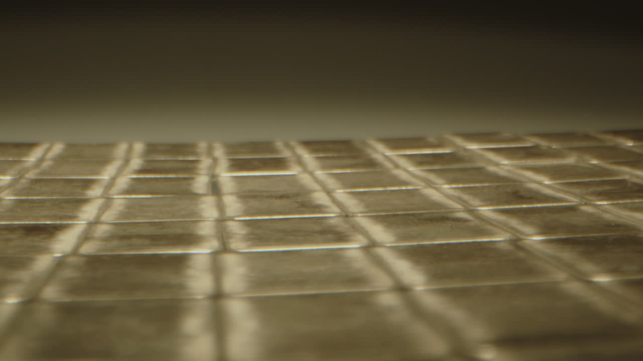 Beautiful macro dolly in of many silver bars neatly spread out on a white surface