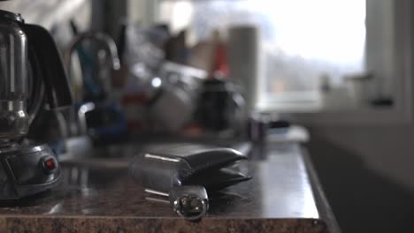 Black-Leather-Bi-fold-Wallet-Placed-On-Top-Of-Kitchen-Countertop---Eye-Level-Shot