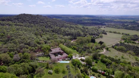 la casa se encuentra en medio de un denso bosque, con el cielo azul adornado por nubes blancas y esponjosas