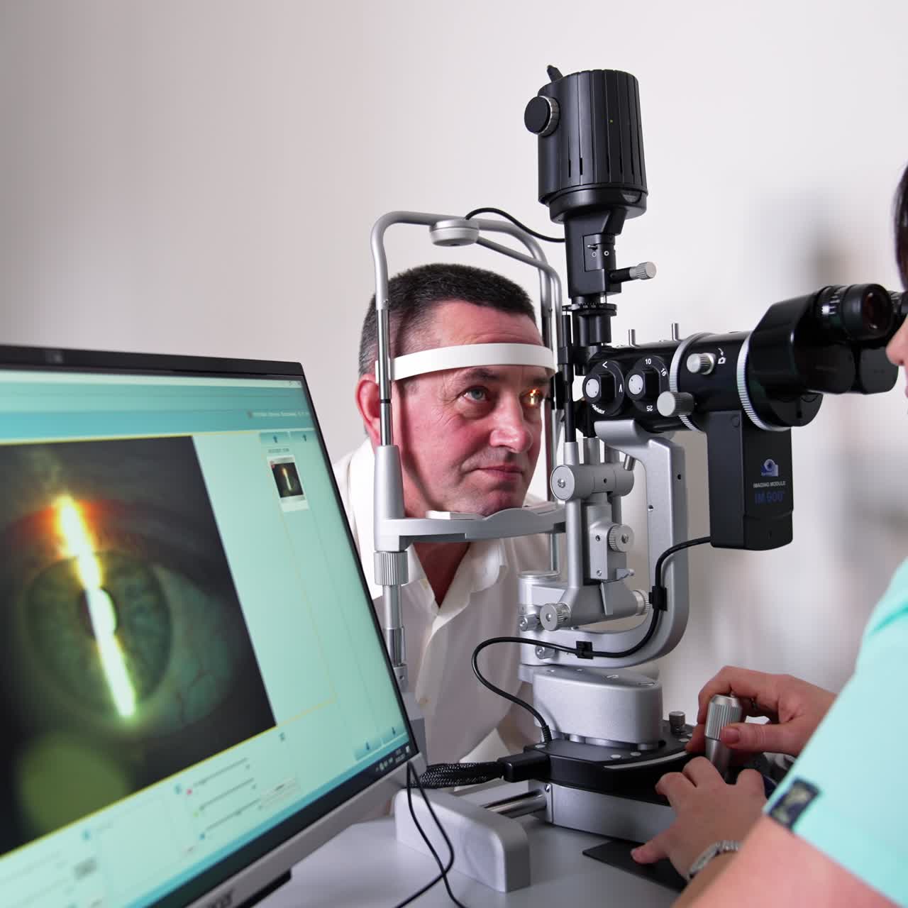 Man going under the ophthalmologist check up. Male patient holds his head in an apparatus while the doctor looks at his eye