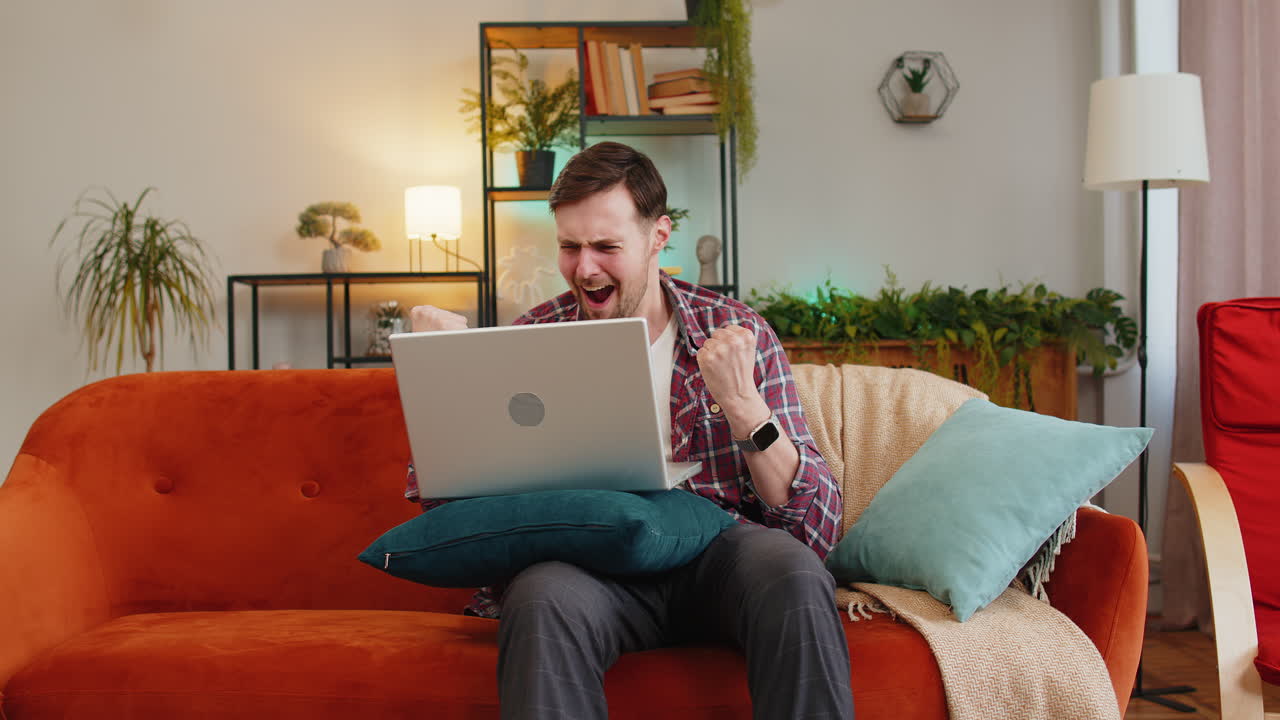 hombre sorprendido usar portátil recibir buenas noticias victoria celebrar lotería premio mayor juego de casino ganar