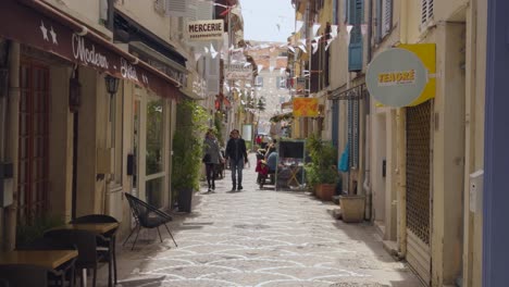 people on cobblestone street in old town of antibes, france. slow motion shot