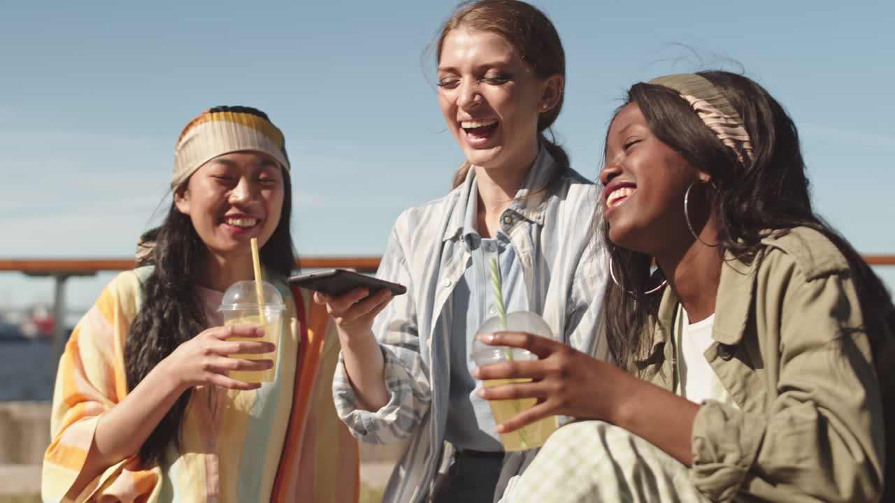 Joyful Girlfriends Recording Funny Voice Messages Outdoors