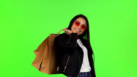 joven feliz posando con sus bolsas de compras en chromakey