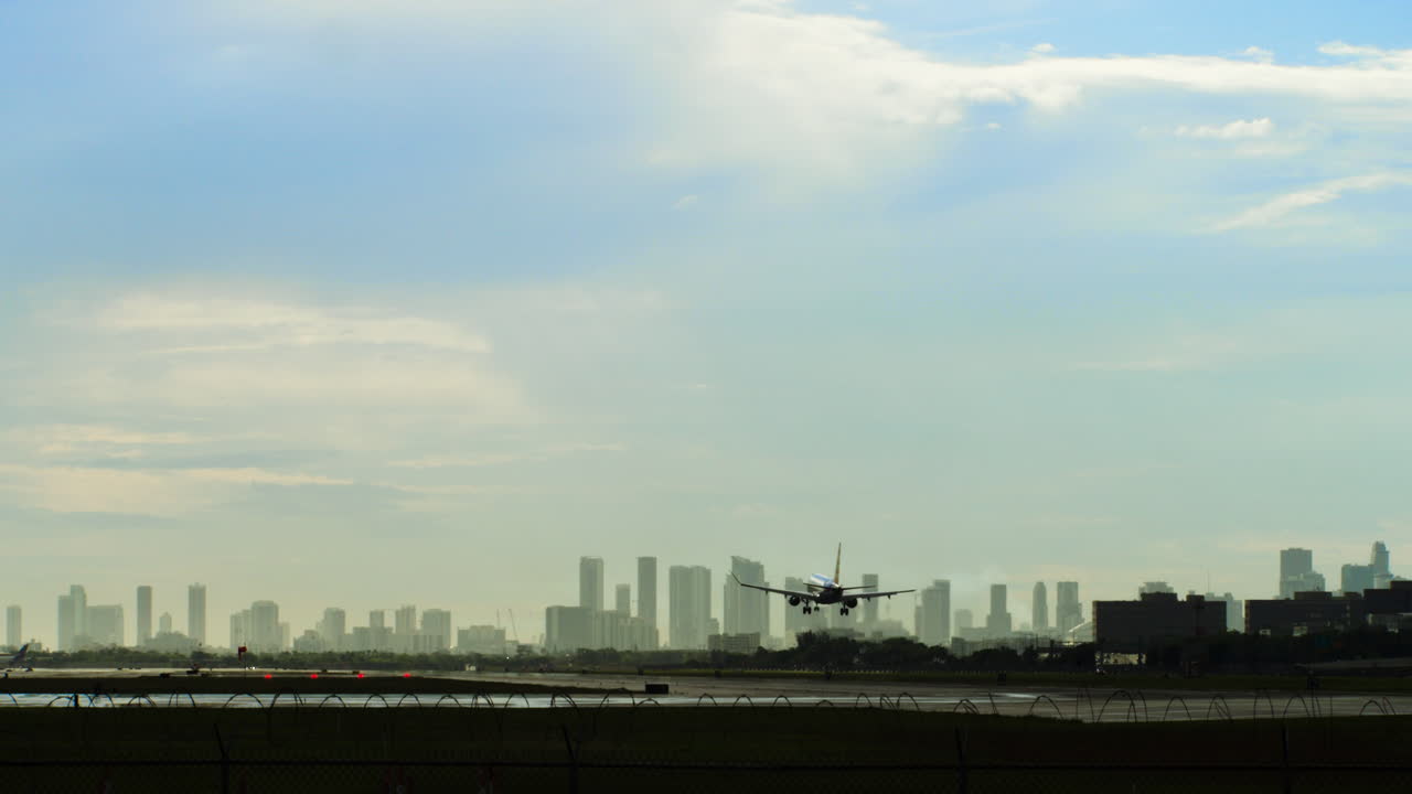 Airplane on Airport Runway with City Skyline in Background