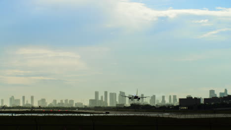 airplane on airport runway with city skyline in background