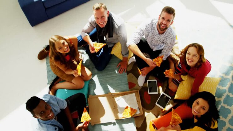Group of happy executives having pizza in office