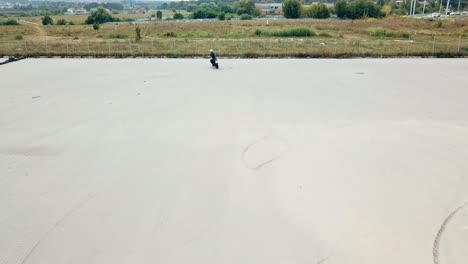 rider making stunt on motorbike. aerial view of young man riding motorcycle on asphalt road