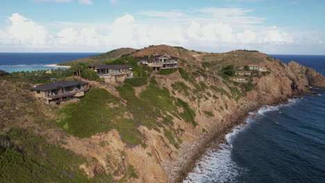 drone shot of private villas above caribbean sea on coastline of british virgin islands