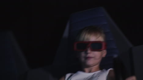 the child is watching a 3d movie in the cinema with special effects and moving chairs 4k video