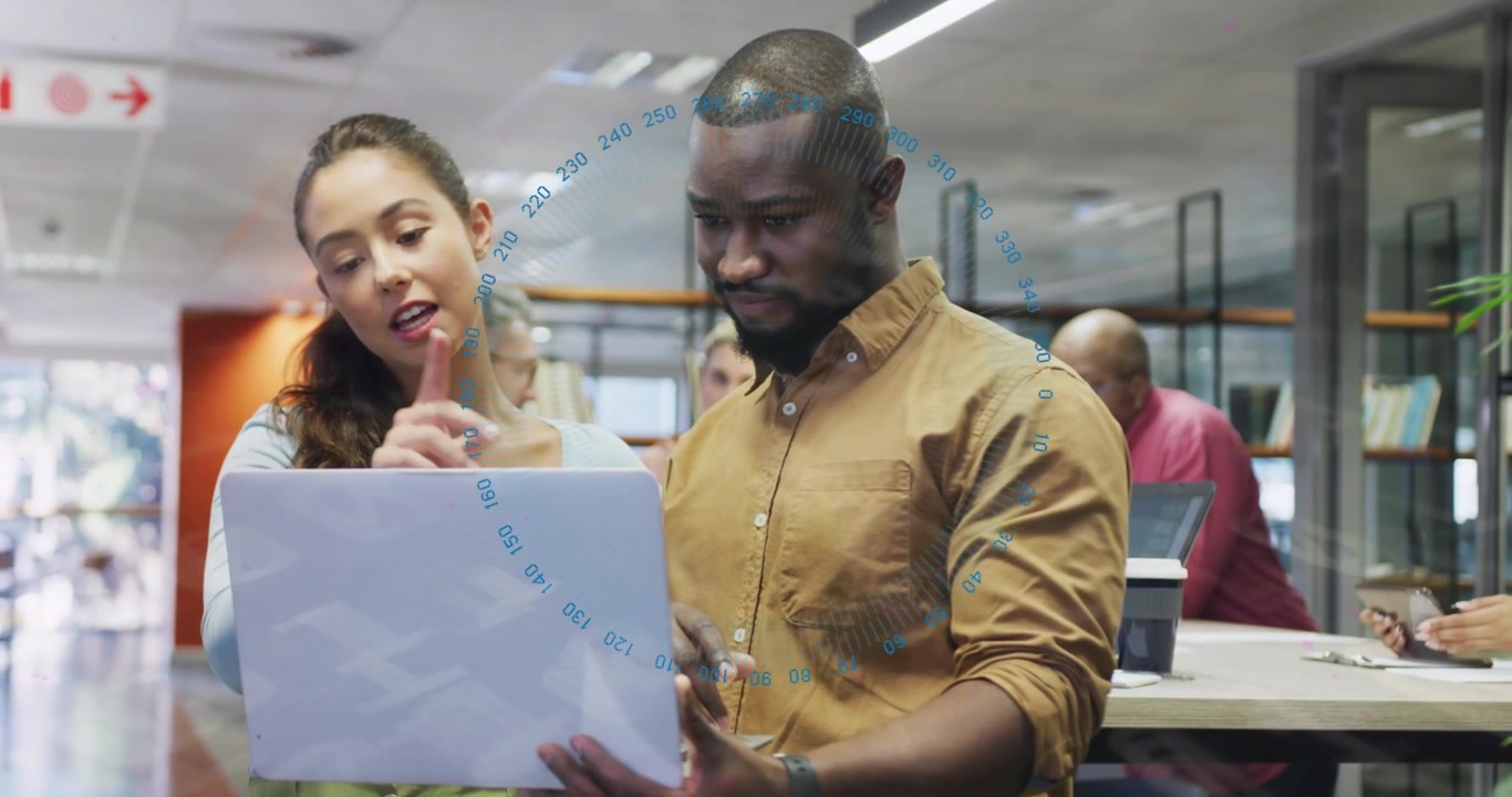 Woman holding laptop and speaking, handing to man in business space, pointing, adjusting, agreeing