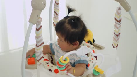 a baby girl enjoys playful moments in her bouncer showcasing joyful care at home.