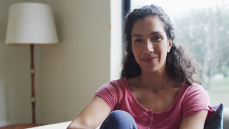 retrato de una mujer de raza mixta feliz , sentada viviendo en una habitación