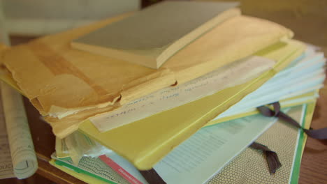 a man's hand throws folders and envelopes of papers onto a pile of documents