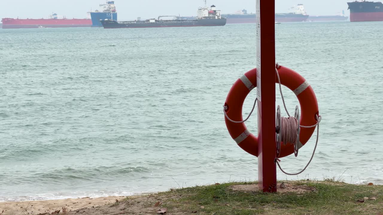 Ampia ripresa statica di un salvagente su un palo che si affaccia su un trafficato canale di navigazione