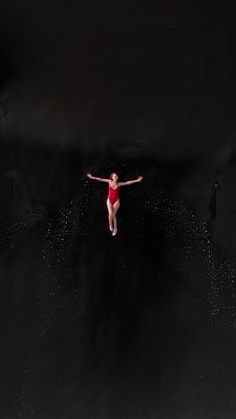 dancer leaps gracefully into the ocean waves under a clear blue sky