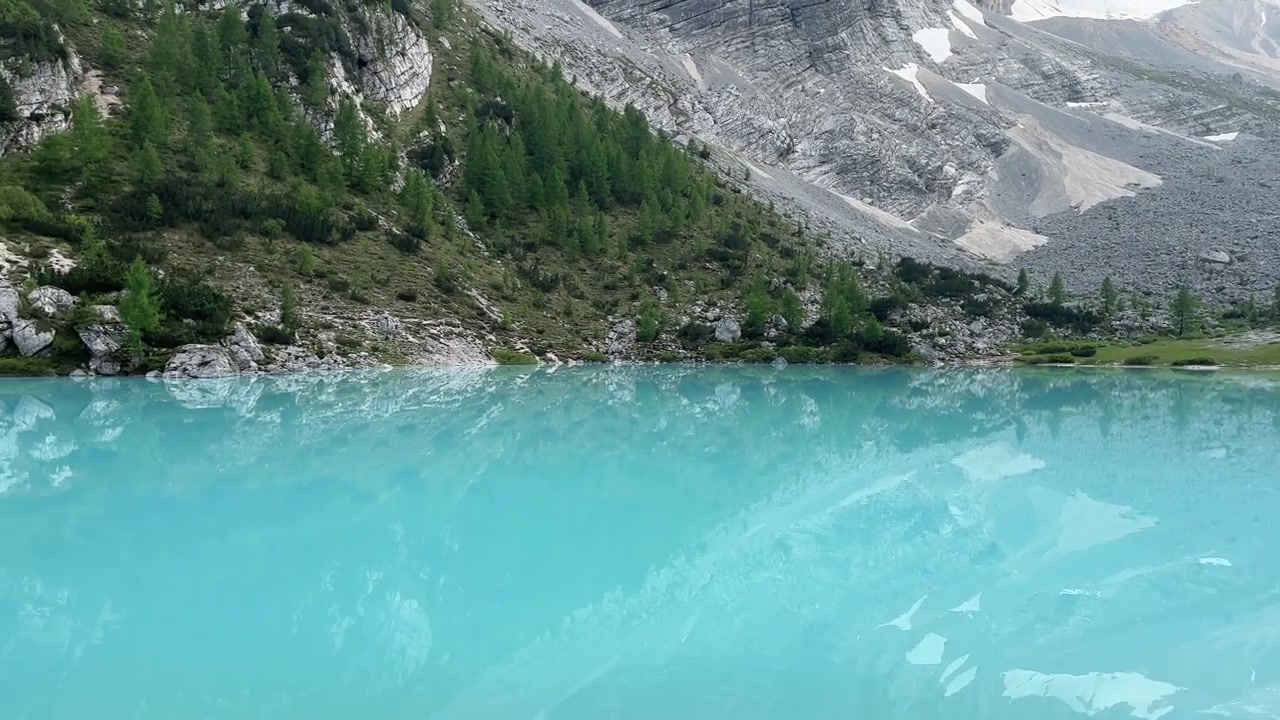 Splendide riprese ravvicinate delle acque blu brillante incredibilmente vivide del Lago di Sorapis, una delle destinazioni alpine più uniche per colore e suggestive delle Dolomiti, Italia settentrionale.