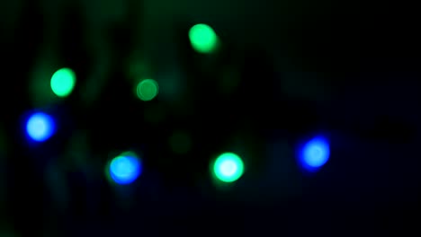silueta borrosa del árbol de navidad con luces desfocalizadas brillantes fuera de foco. video vertical 4k interior de año nuevo de xmas con luces de colores de fondo. círculo brillante efecto bokeh parpadeante.