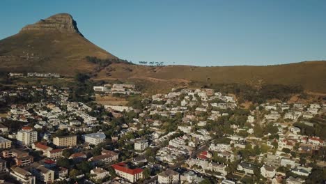 drone circling around an urban neighborhood with lion's head mountain in the background in cape town south africa